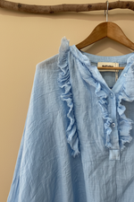 Carica l'immagine nel visualizzatore della galleria,Blusa azul detalhe etiqueta com fundo bege estúdio
