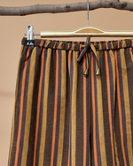 Cargue la imagen en el visor de la galería,Calças riscas com fundo de estúdio bege - detalhe cintura
