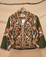 Carregar imagem no visualizador da galeria, Casaco bordado verde com fundo de estúdio bege - frontal
