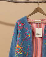 Carregar imagem no visualizador da galeria, Casaco denim bordado fundo bege - detalhe
