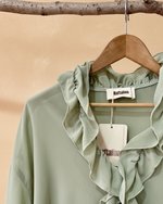 Carregar imagem no visualizador da galeria, Detalhe blusa verde - fundo bege
