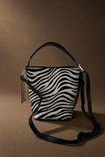 Load image in the gallery viewer,Mala zebra vista frontal com etiqueta, fundo castanho quente
