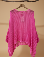 Carregar imagem no visualizador da galeria, Poncho rosa pink de malha vazada - vista frontal com mangas largas
