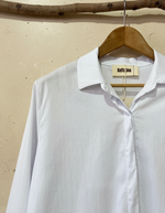 Carregar imagem no visualizador da galeria, White shirt collar detail with beige studio background
